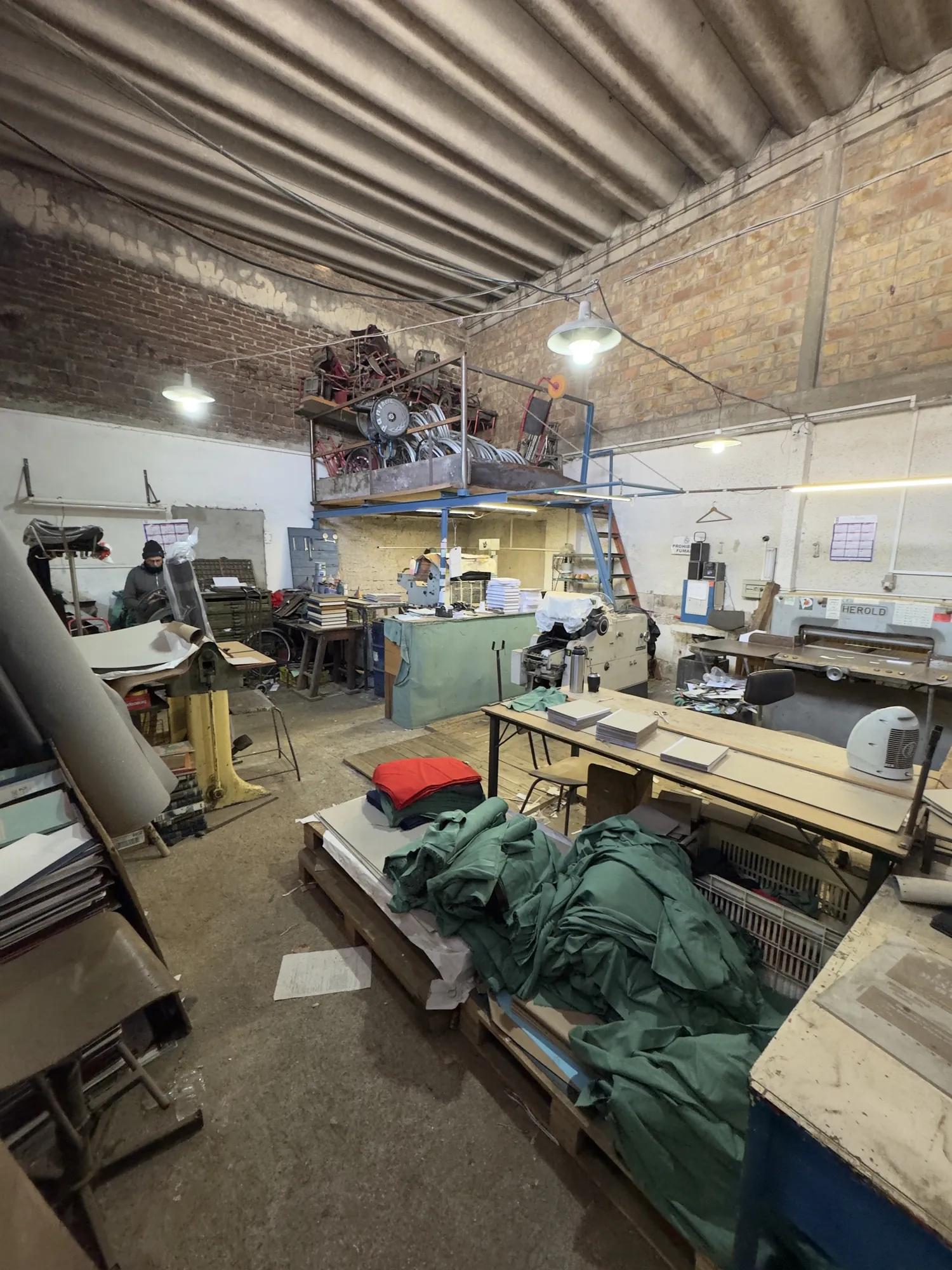 Vista general del taller de imprenta, con entrepiso de guardado y equipamiento de producción.